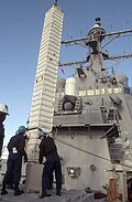 A Tomahawk missile canister being loaded into a VLS aboard the Arleigh Burke-class destroyer USS Curtis Wilbur