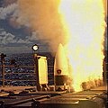 An SM-3 departs the Mk 41 VLS aboard USS Lake Erie with uptake hatch and cell hatch open.