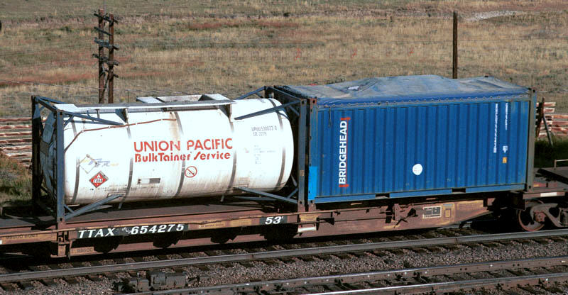 A spine car with a 20 ft tanktainer and an open-top 20 ft container with canvas cover.