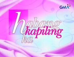 An image with a pink and white background. The series title is displayed on the center of the image. The logo of GMA Network is displayed on the upper right side of the image.