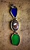 Fordite (center) on a piece of jewelry alongside blue and green beach glass, 2013
