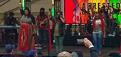Musicians performing onstage with fists raised