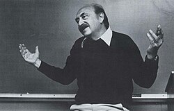 A smiling man gesturing.