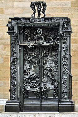 Ornate, bronze door panels and frame showing figures and scenes in relief.