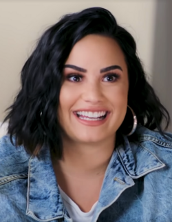 Portrait of Demi Lovato smiling in a jean jacket