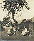 Street in Akropong, with trees under which elders sit for palavers, 1890s