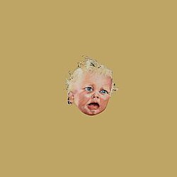 an unhappy baby's face in the middle of a plain brown background