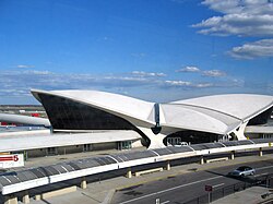 Exterior view as seen in 2006, before either T5 or the TWA Hotel opened. There is a curved glass canopy in front of the building. Behind it is a tarmac.