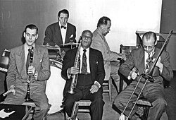 The house band accompanying Sidney Bechet at his first residency at the Jazz, Ltd. club, November 1947[1] Left to right: Bill Reinhardt, Danny Alvin, Bechet, Mel Grant, Munn Ware