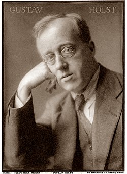 head of a man, wearing glasses, and resting his head on his right hand