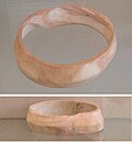 Indus bracelet, front and back, made of Pleuroploca trapezium or Turbinella pyrum imported to Susa in 2400–2100 BC. Found in the tell of the Susa acropolis. Louvre Museum, reference Sb 14473.[66] This type of bracelet was manufactured in Mohenjo-daro, Lothal and Balakot.[67] The back is engraved with an oblong chevron design which is typical of shell bangles of the Indus Civilization.[68]