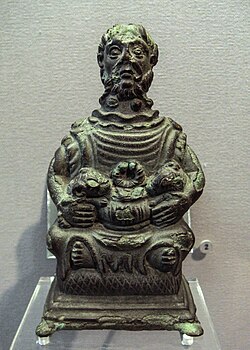 The Étang-sur-Arroux statuette of Cernunnos. He has two torcs and two holes at the top of his head, probably to receive deer antlers. Above his ears are two small faces.: no 10 