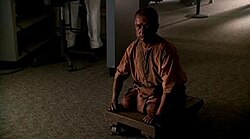 A man who is missing his legs rests on a wheeled cart.