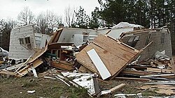 Well-built structures can suffer serious damage, including roof loss, and the collapse of some exterior walls may occur in poorly built structures. Mobile homes, however, are destroyed. Vehicles can be lifted off the ground, and lighter objects can become small missiles, causing damage outside of the tornado's main path. Wooded areas have a large percentage of their trees snapped or uprooted.