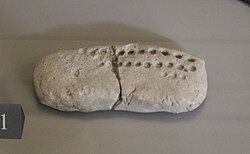Numero-ideographic tablet from Tepe Sialk (the dots are numerical signs; the ideographic sign is on the other side), c. 3500 – c. 3350 BC. Louvre Museum.