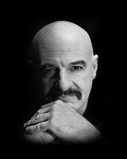 Black and white closeup photo of a bald man's face