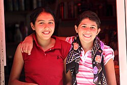 Photo of two young people standing closely together and smiling
