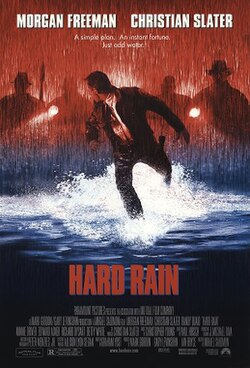 A rain scene with a man running through shallow water, behind him follow hooded figures with torches.