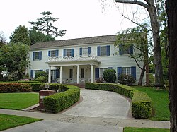 A white house with blue shutters is pictured