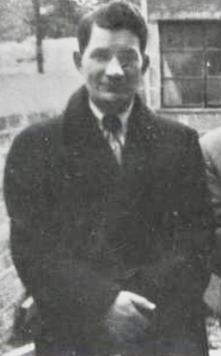 Photograph of Peter Tyrrell, a man with short dark hair wearing a dark coat and smiling with his mouth closed