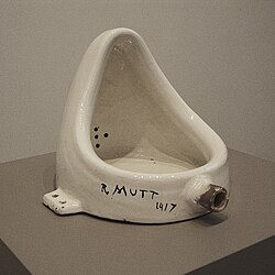 A white porcelain urinal with "R. Mutt" in messy writing