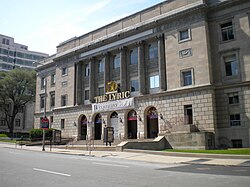 A four-story neoclassical building in a downtown setting