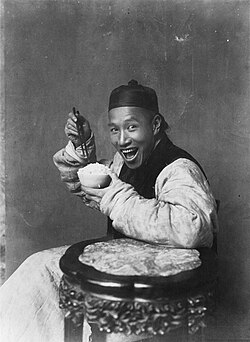 In the late 19th century and early 20th century, photographs taken in the United Kingdom rarely depicted people smiling, in accordance with the cultural conventions of Victorian and Edwardian society. In contrast, the photograph Eating Rice, China (1904) depicts a smiling Chinese man.