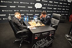 Professionals sat at a table playing chess, visibly focused