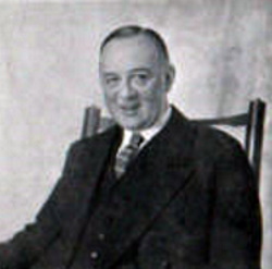 middle-aged white man with neat moustache and receding hair