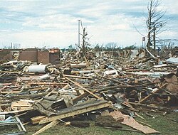 Well-built homes are reduced to a short pile of medium-sized debris on the foundation. Homes with poor or no anchoring are swept completely away. Large, heavy vehicles, including airplanes, trains, and large trucks, can be pushed over, flipped repeatedly, or picked up and thrown. Large, healthy trees are entirely debarked and snapped off close to the ground or uprooted altogether and turned into flying projectiles. Passenger cars and similarly sized objects can be picked up and flung for considerable distances.