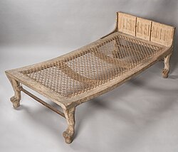 Wooden bed with strung cord mattress and lion-shaped legs