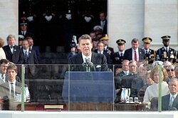 Reagan speaking at the podium with dignitaries behind