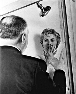 A man talking to a woman standing in a shower.