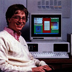 Bill Gates next to a Tandy 2000 running a development version of Windows 1.0