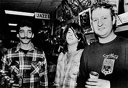 Three men standing and holding drink cans