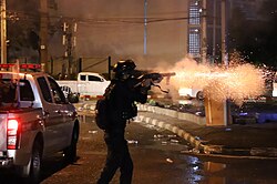Riot Police fire tear gas to anti-government protesters during Din Daeng Protests in August 2021.