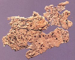 Fragment of ancient Chinese paper map with features in black ink, found on the chest of the occupant of Tomb 5 of Fangmatan, Gansu in China in 1986, from early Western Han, 2nd century BC, 5.6 cm × 2.6 cm (2.2 in × 1.0 in).