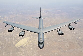 Aerial top/side view of gray B-52H flying over Texas