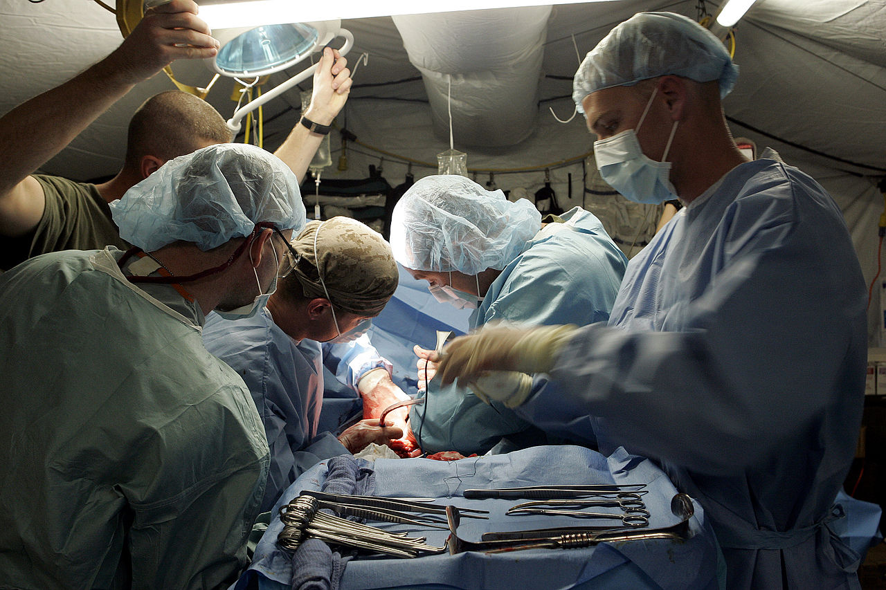 US Navy 041117-M-0000G-004 U.S. Navy Surgeons and Hospital Corpsman, assigned to the Surgical-Shock Trauma Platoon (SSTP) at Camp Taqaddum, Iraq, operate on a Marine.jpg