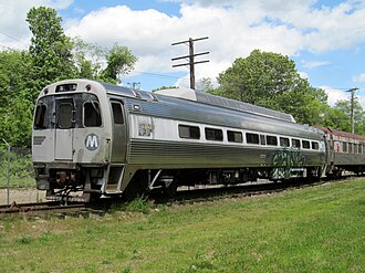 A silver railroad coach on a siding