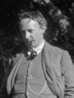 Black-and-white photo of man wearing a suit with a pipe in his mouth