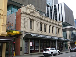 The same building as before, fully restored and with a modern development behind
