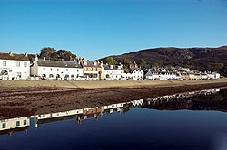 A view of buildings along Shore Street, with Loch Broom in foreground