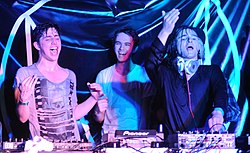 Photograph of three DJs performing a set