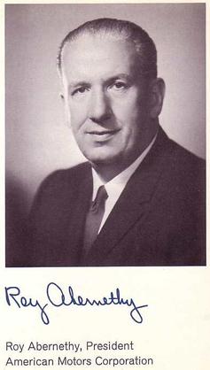 Black and white portrait of Roy Abernethy, an American automobile executive. The photograph was taken from the automaker's annual report. Abernethy is wearing a dark suit, white shirt, and dark tie. He is looking straight at the camera, with a slight smile, and hair swept back from his forehead. His signature is below the picture.