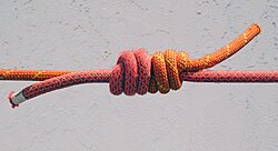 Two ropes joined by a triple fisherman's knot, the ropes extend to the left and right of the image