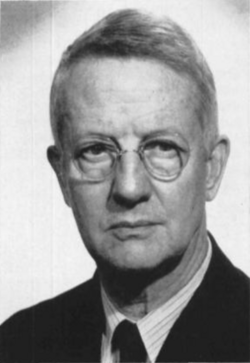 A black and white photograph of a man wearing a suit