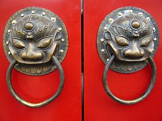 A traditional red Chinese door with Imperial guardian lion knocker