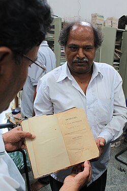 Gowda pictured in 2012 holding a Canarese-English dictionary by Daniel Sanderson printed in 1838