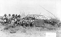 "Scene in Geronimo's camp before surrender to General Crook, March 27, 1886: group in Natches' camp; boys with rifles."
